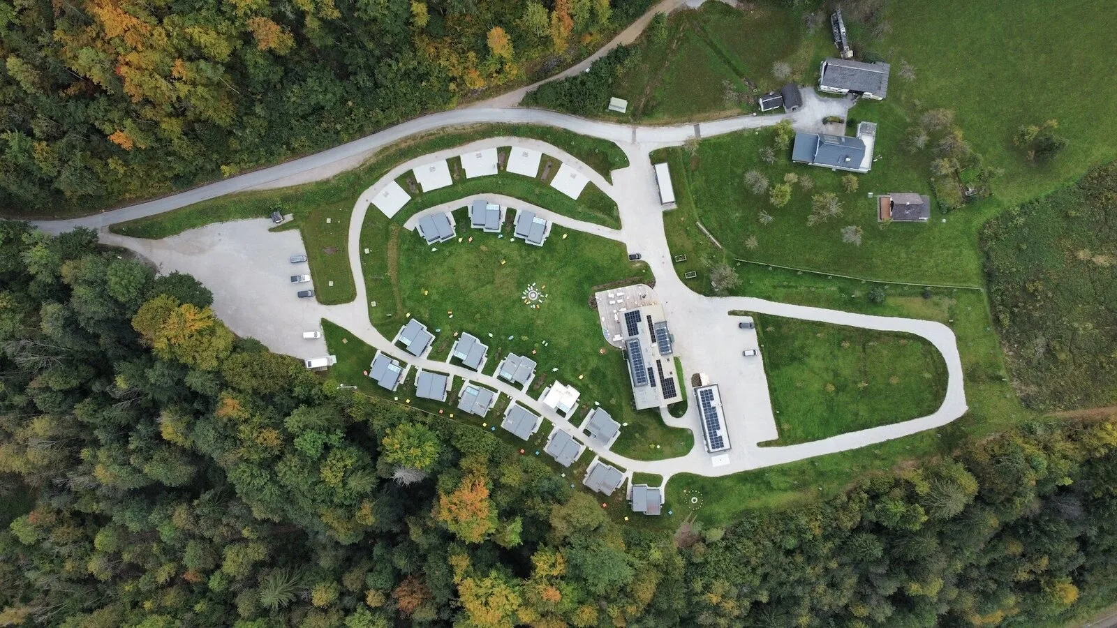 Luftaufnahme von The Campus Alps im Talboden bei Hieflau — Clubhaus und Tiny Homes zwischen Wiesen und Bergen